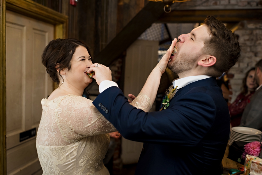 A wedding couple smash cake in each other's faces.